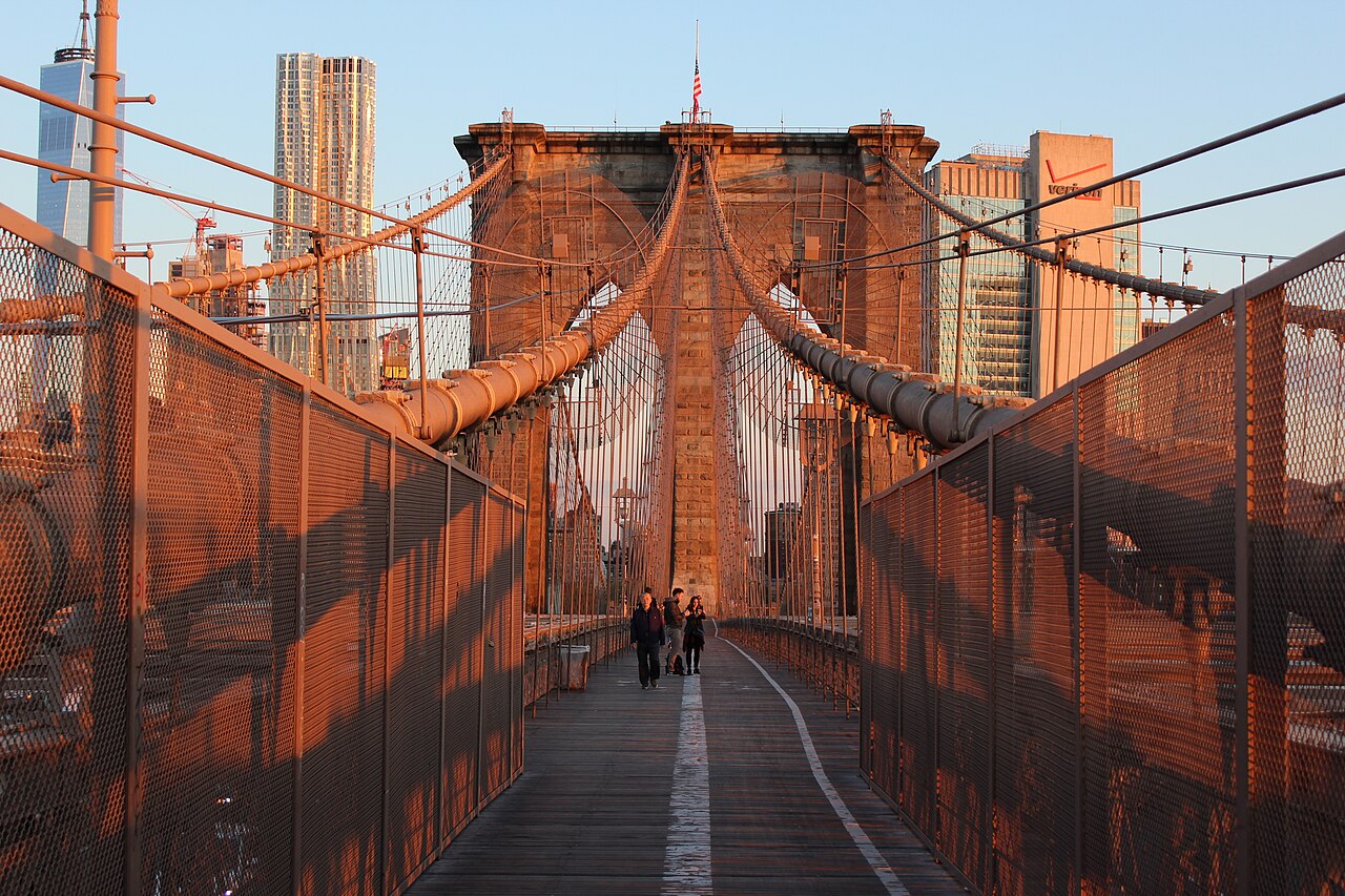Passarela de pedestres da Brooklyn Bridge com a estrutura de cabos e Manhattan ao fundo
