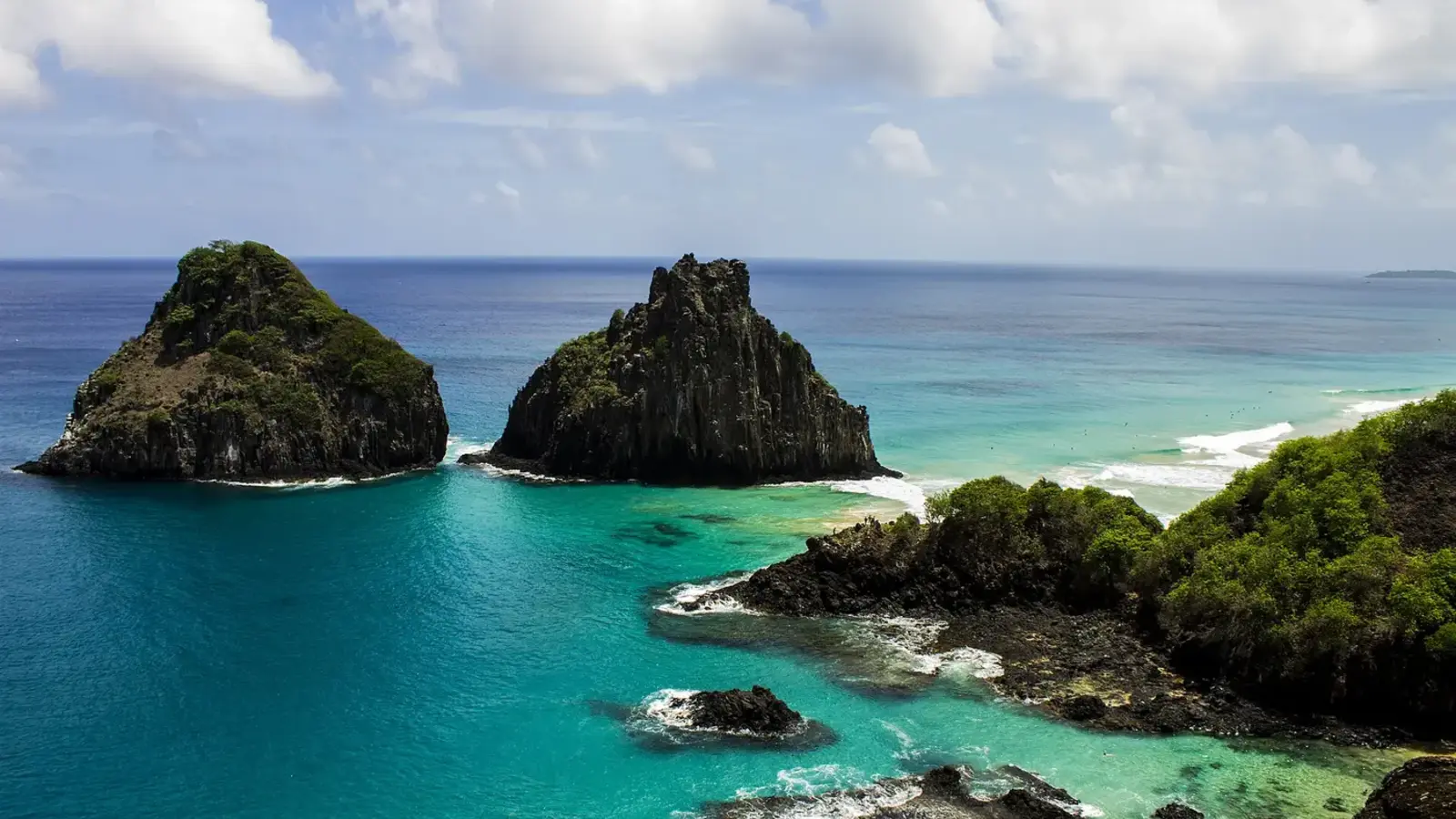 Morro Dois Irmãos e águas azul-turquesa vistos da Baía dos Porcos