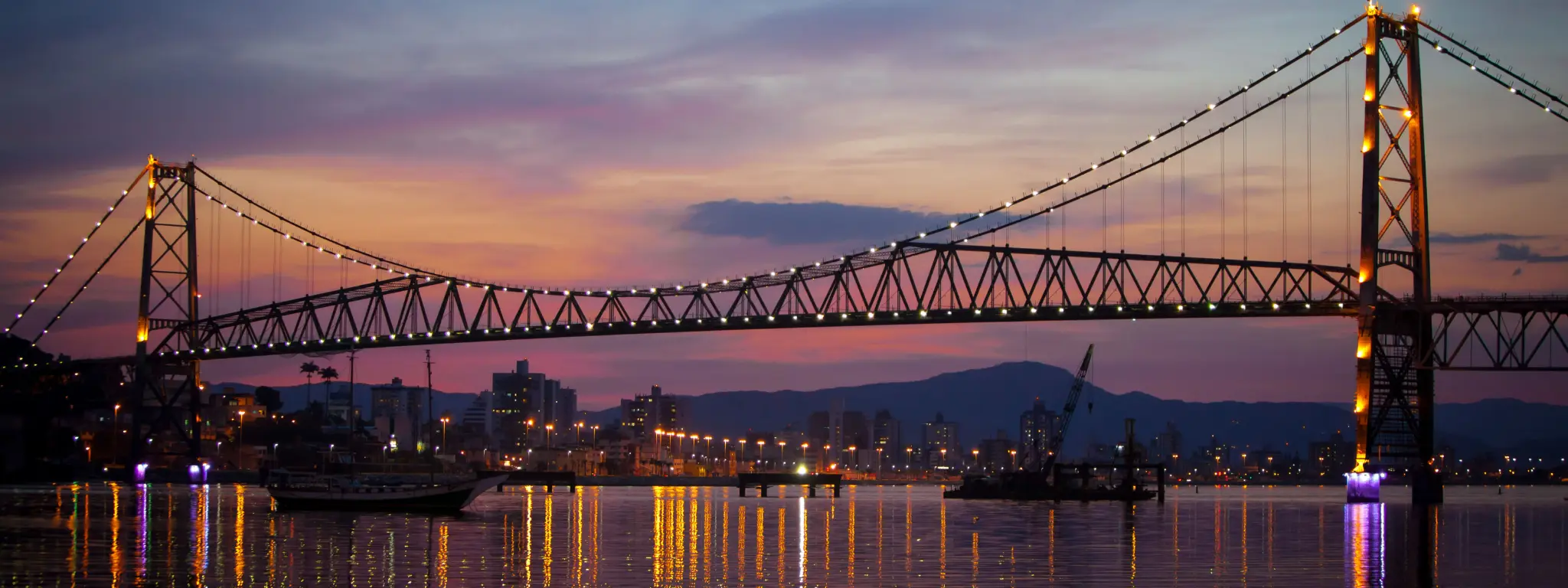 Ponte Hercílio Luz iluminada ao entardecer em Florianópolis