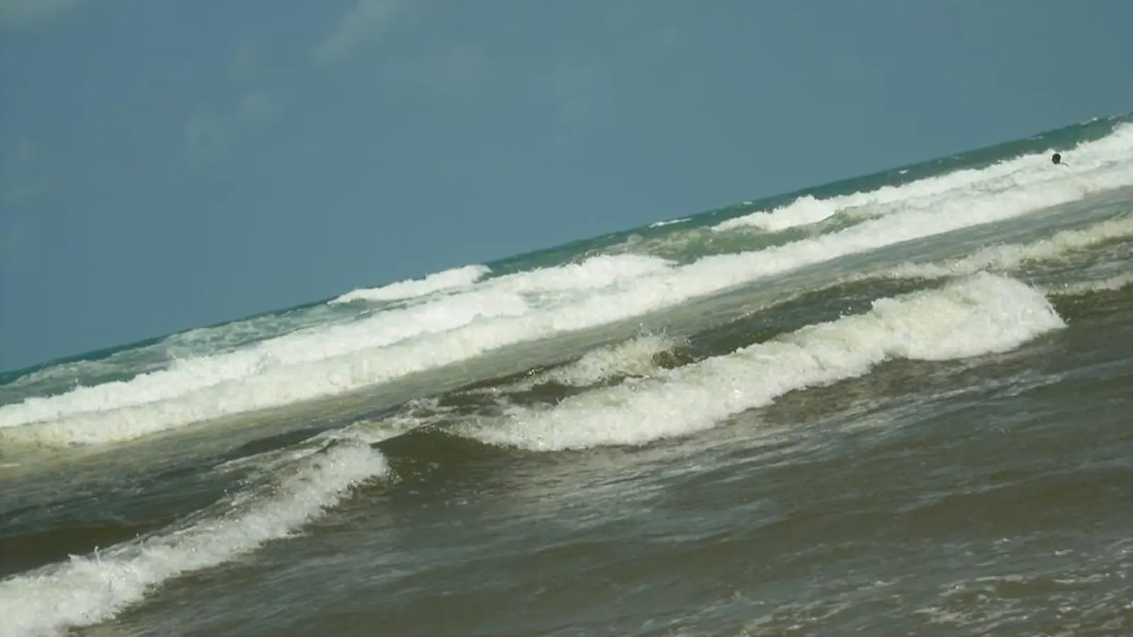 Ondas chegando à extensa faixa de areia da Praia do Futuro em Fortaleza