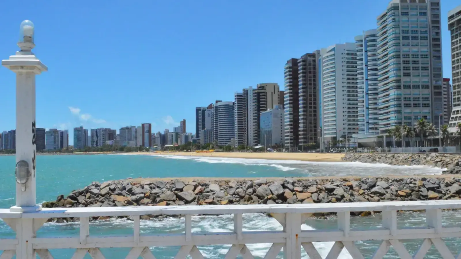 Praia de Iracema e edifícios da orla de Fortaleza sob o céu azul