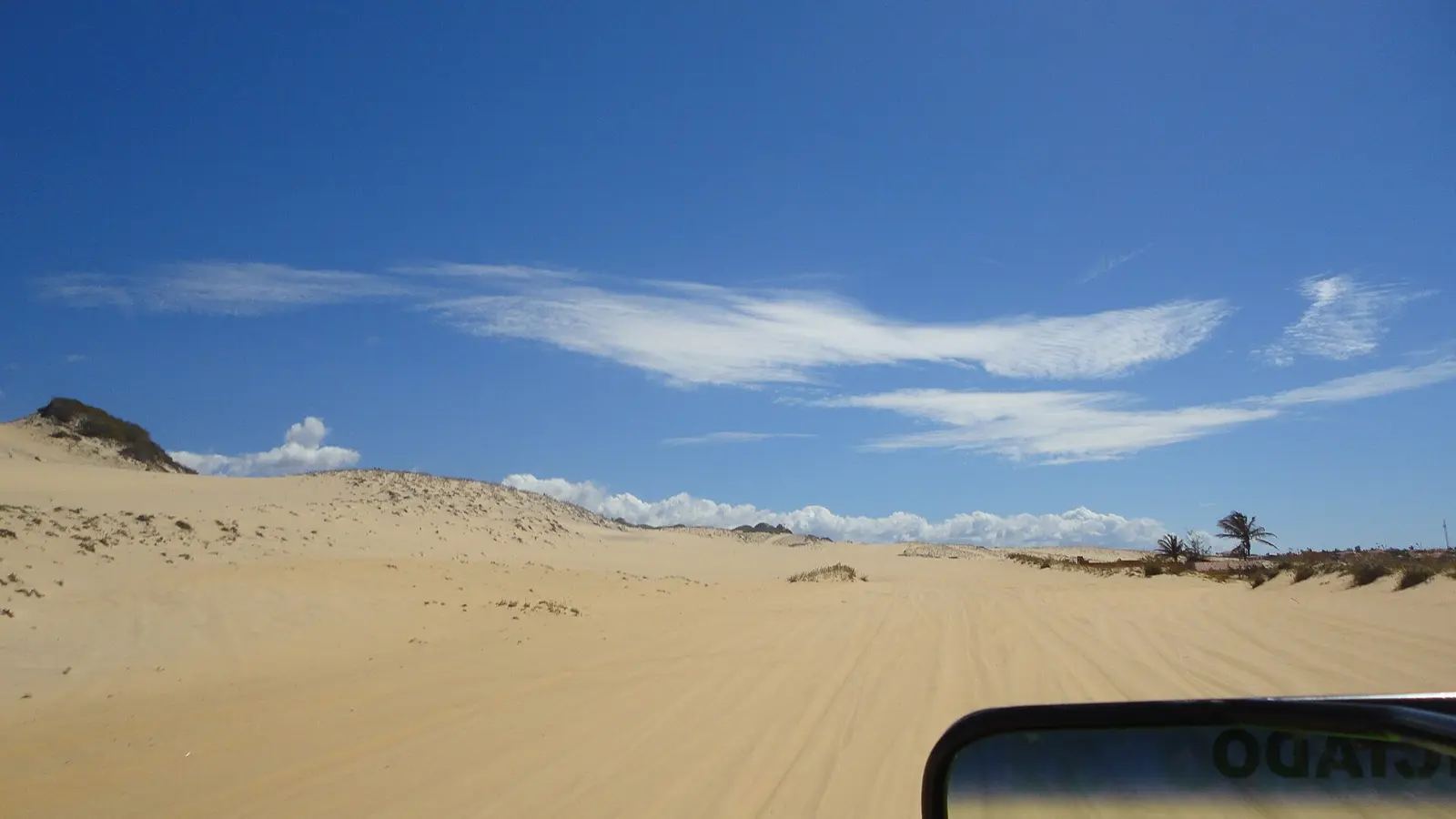 Buggy percorrendo as dunas de Cumbuco sob o céu azul