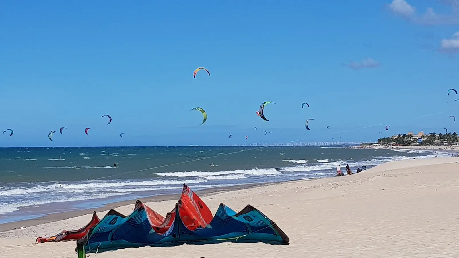 Kitesurfistas e equipamentos na faixa de areia da Praia de Cumbuco